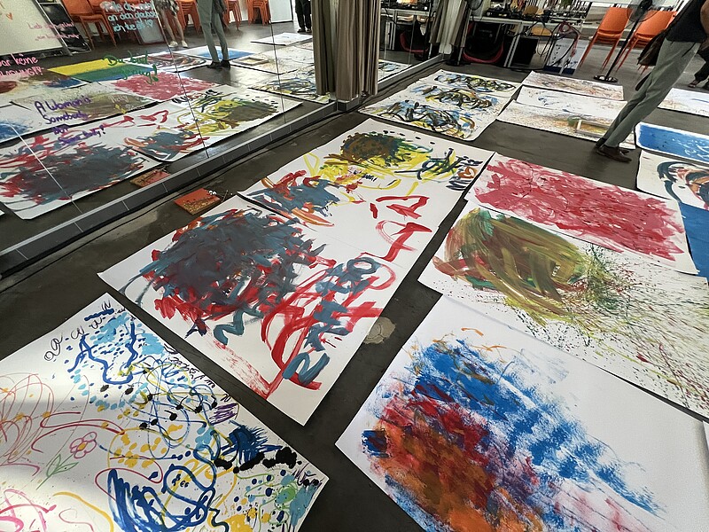 Bunte abstrakte Kunstwerke auf dem Boden verteilt, entstanden im Projekt 'Inklusiver Kunstguide'